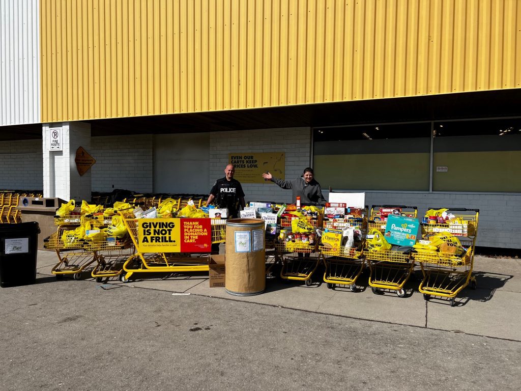 police officer and volunteer collect food donations ad No Frills