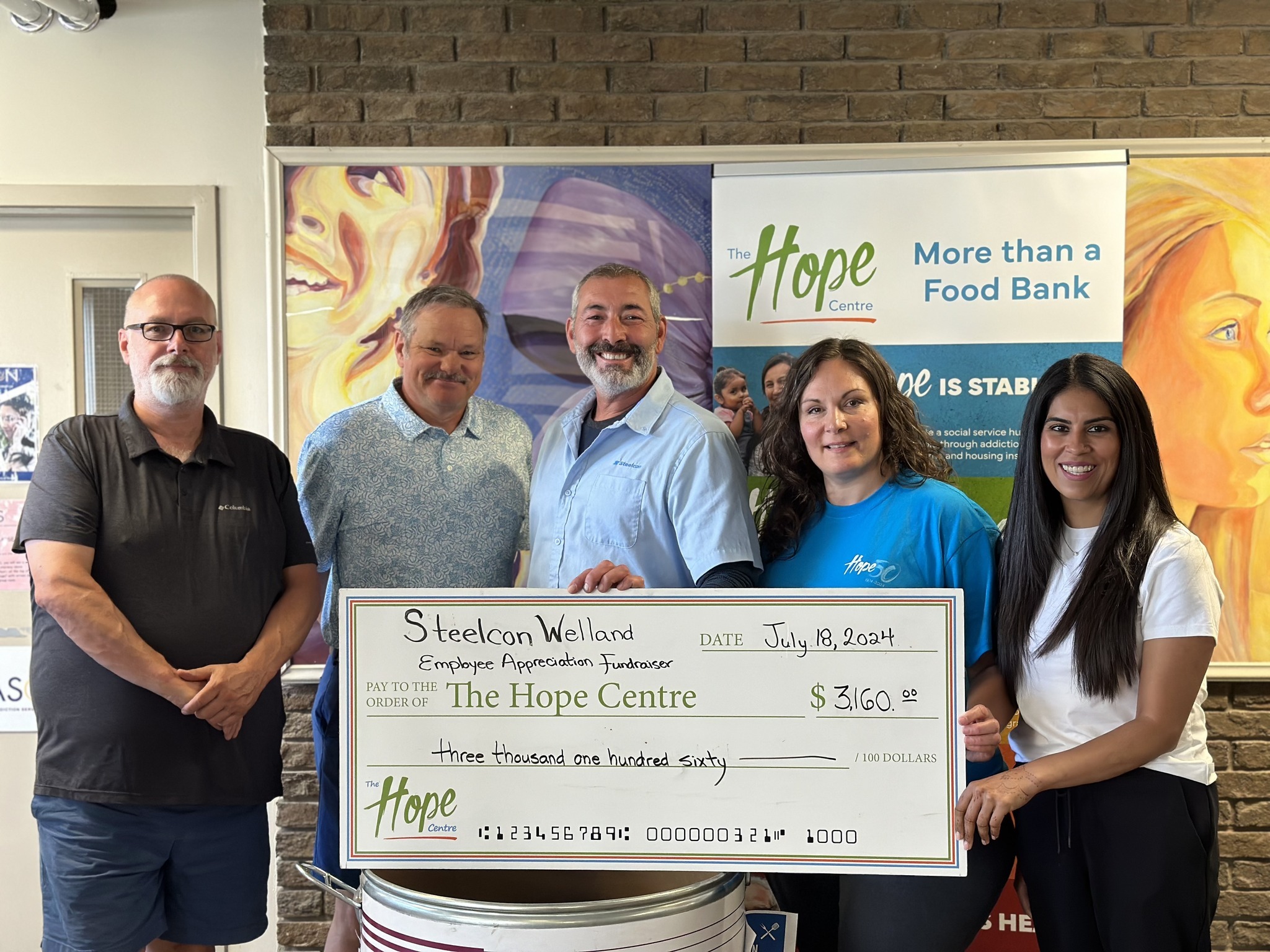 Group photo with The Hope Centre Staff and Steelcon Employees presenting a donation cheque